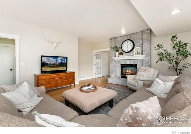 living area with visible vents, a fireplace, wood finished floors, baseboards, and recessed lighting