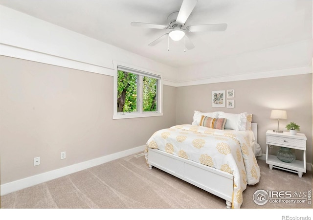 carpeted bedroom featuring baseboards and a ceiling fan