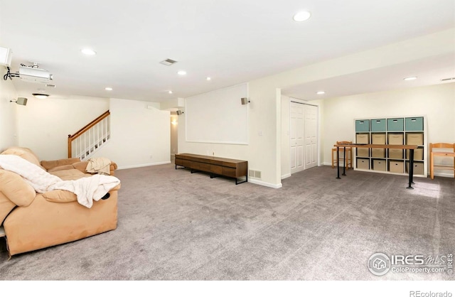 carpeted living area featuring baseboards, visible vents, recessed lighting, and stairs