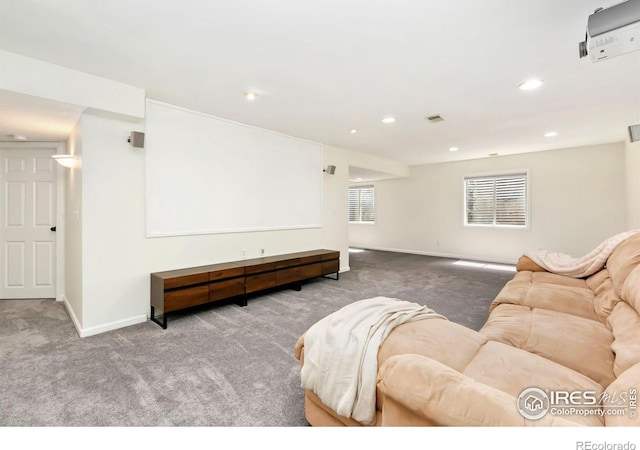 carpeted living area featuring recessed lighting, baseboards, and visible vents