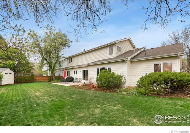 rear view of house featuring fence, a storage unit, an outbuilding, a patio area, and a yard