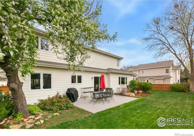 back of property with a yard, a patio, and fence