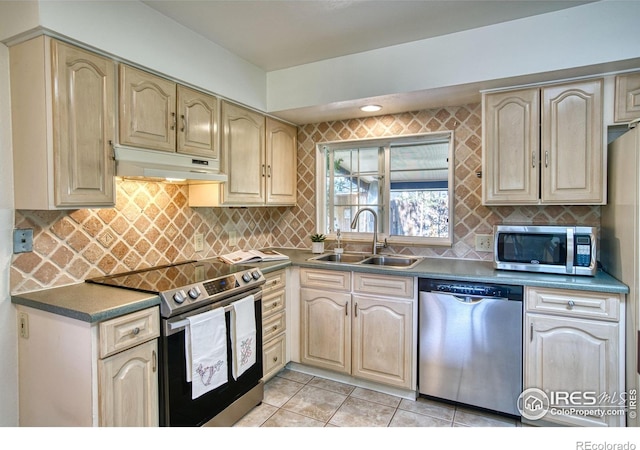kitchen with decorative backsplash, light tile patterned flooring, under cabinet range hood, a sink, and stainless steel appliances