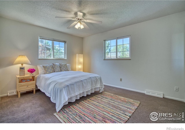 carpeted bedroom with a textured ceiling, visible vents, and multiple windows