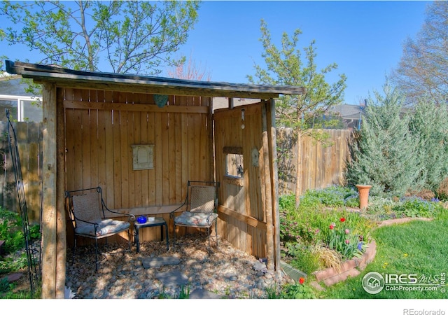view of outbuilding featuring fence and an outbuilding