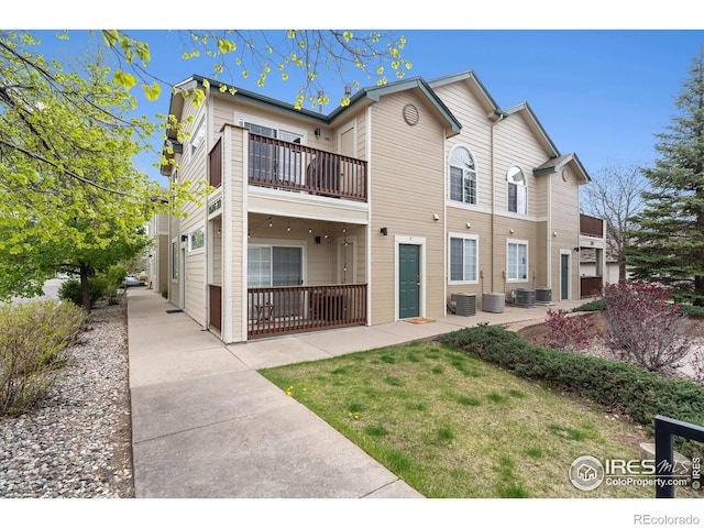 rear view of house with central AC unit, a patio area, and a balcony