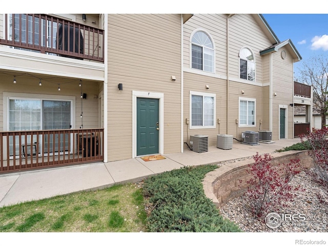 exterior space featuring a patio, central AC unit, and a balcony