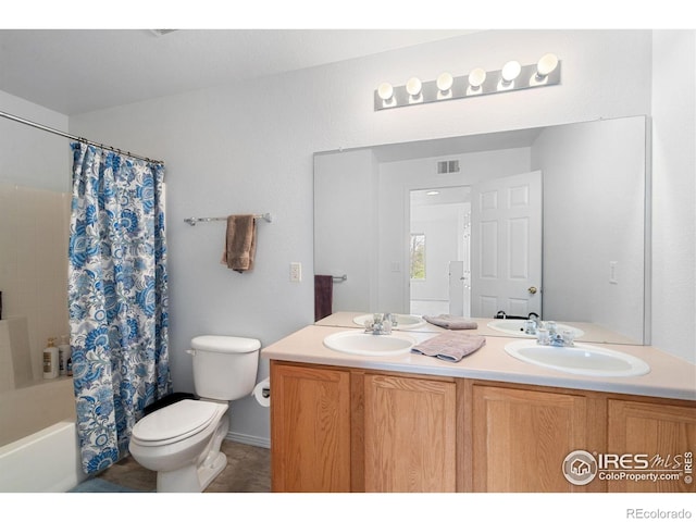 full bath featuring double vanity, a sink, shower / bath combination with curtain, and toilet