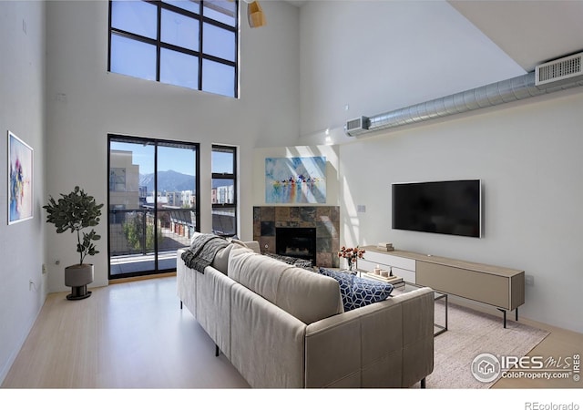 1200 Yarmouth Ave Unit 238, Boulder, CO 80304 - living room with a fireplace, visible vents, wood finished floors, and a towering ceiling