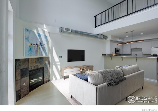 1200 Yarmouth Ave Unit 238, Boulder, CO 80304 - living area featuring a fireplace, visible vents, a towering ceiling, and light wood-type flooring