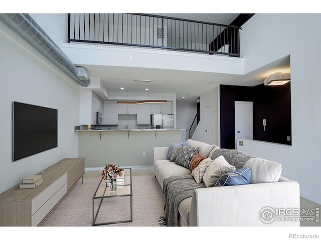 living room with stairway, light carpet, recessed lighting, and a towering ceiling