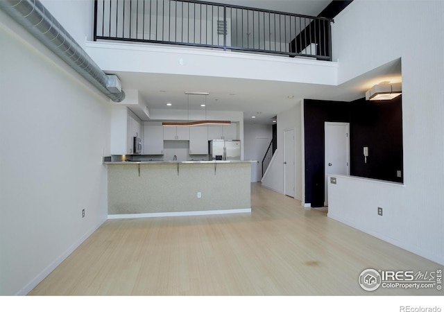 1200 Yarmouth Ave Unit 238, Boulder, CO 80304 - kitchen with a towering ceiling, light countertops, a peninsula, a breakfast bar, and stainless steel appliances