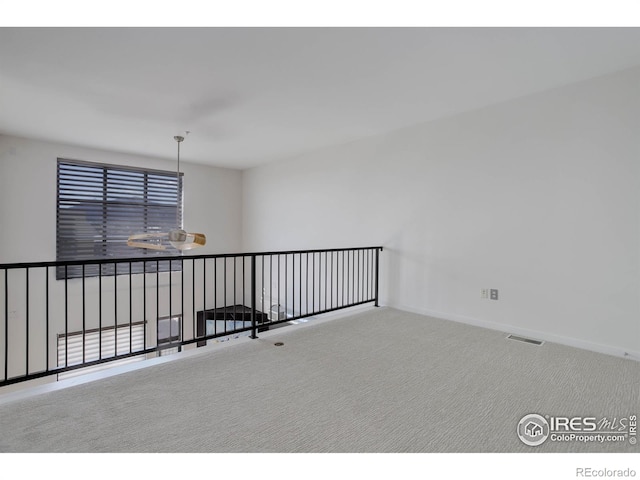 unfurnished room featuring carpet floors, baseboards, and visible vents