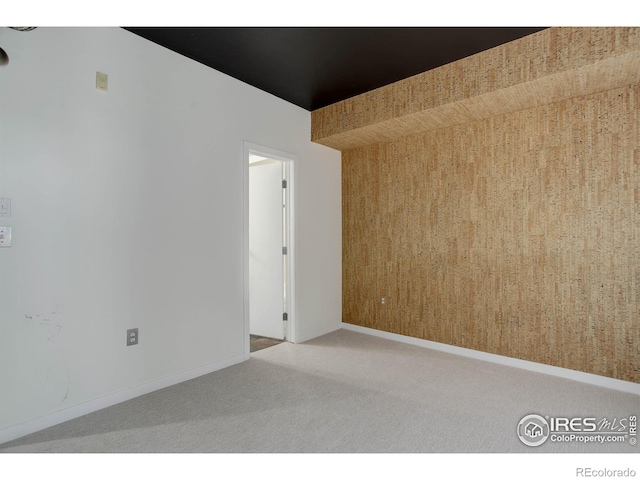 carpeted empty room featuring baseboards