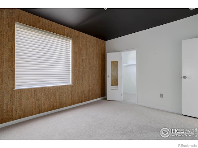 carpeted empty room with baseboards
