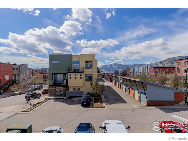 view of building exterior with uncovered parking and a mountain view