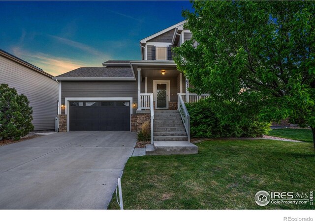 672 Dakota Way, Windsor, CO 80550 - view of front of property featuring driveway, a lawn, stone siding, and a garage