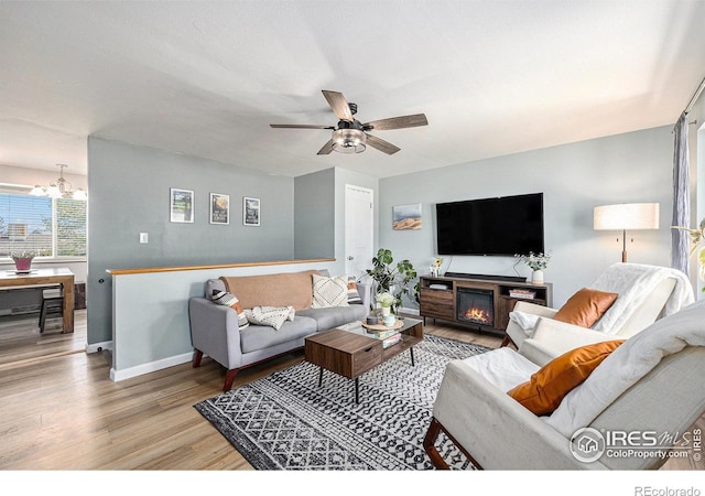 7960 Estes Ct, Arvada, CO 80005 - living room featuring baseboards, ceiling fan with notable chandelier, and wood finished floors