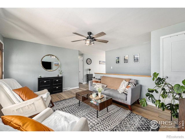living area featuring baseboards, a ceiling fan, wood finished floors, and visible vents