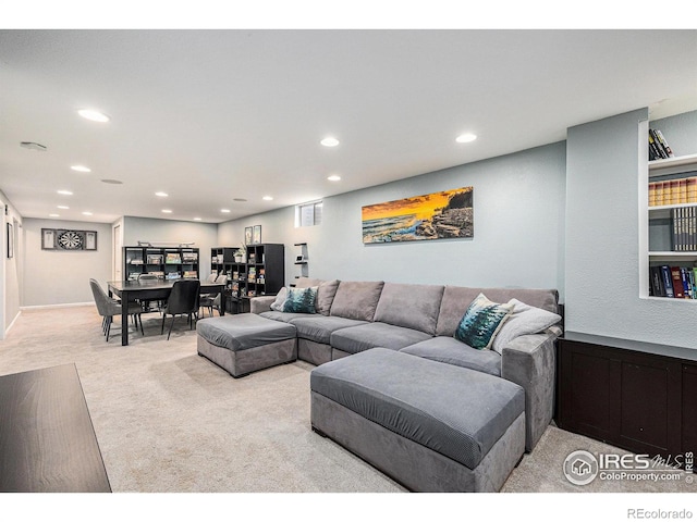 living area with recessed lighting and light carpet