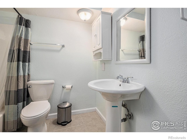 bathroom with toilet, baseboards, curtained shower, and tile patterned flooring