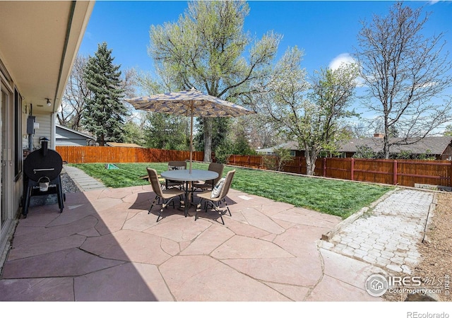 7960 Estes Ct, Arvada, CO 80005 - view of patio featuring a fenced backyard, outdoor dining area, and area for grilling