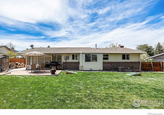 7960 Estes Ct, Arvada, CO 80005 - back of house with a chimney, a lawn, brick siding, fence, and a patio