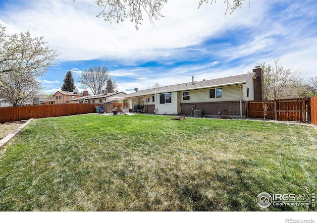 7960 Estes Ct, Arvada, CO 80005 - back of house with a yard, brick siding, a chimney, and a fenced backyard