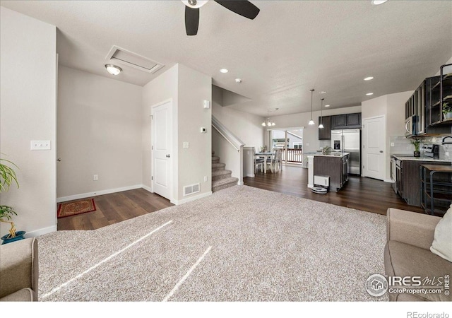living area with visible vents, stairs, recessed lighting, a ceiling fan, and dark wood finished floors