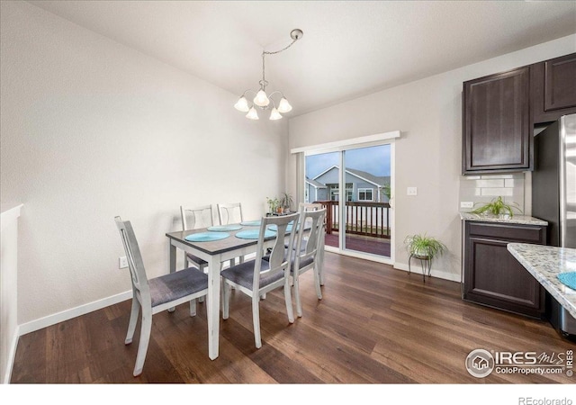 dining room featuring dark wood-style flooring, baseboards, and an inviting chandelier