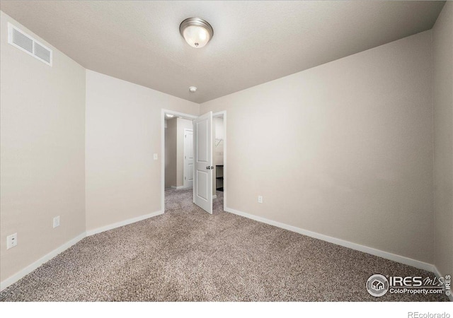 unfurnished bedroom with carpet floors, baseboards, and visible vents