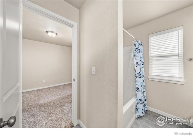 full bath featuring baseboards and shower / bathtub combination with curtain