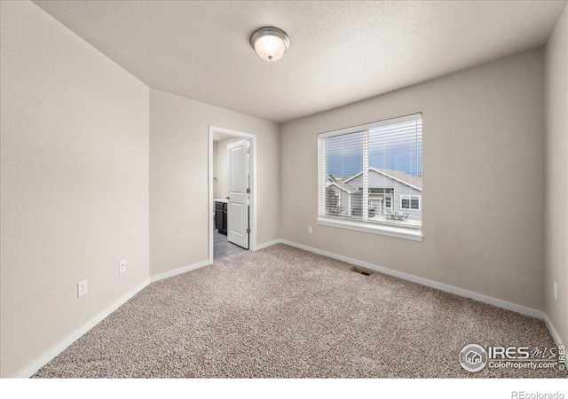 carpeted empty room with baseboards and visible vents