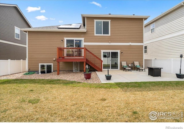 back of property featuring stairs, a fenced backyard, solar panels, a patio, and a yard