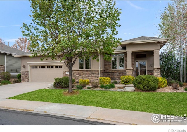 6836 Spanish Bay Dr, Windsor, CO 80550 - view of front of property with driveway, a front lawn, an attached garage, stone siding, and stucco siding
