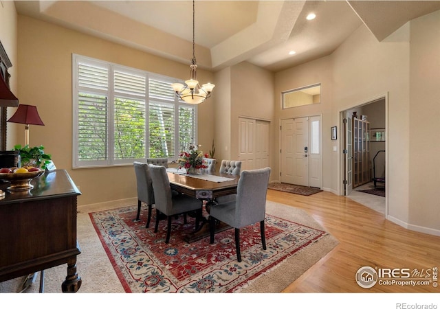6836 Spanish Bay Dr, Windsor, CO 80550 - dining area with light wood-type flooring, baseboards, a chandelier, a high ceiling, and recessed lighting