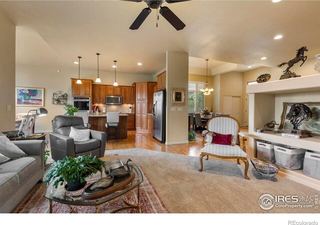6836 Spanish Bay Dr, Windsor, CO 80550 - living room featuring ceiling fan with notable chandelier, recessed lighting, and light wood-style flooring