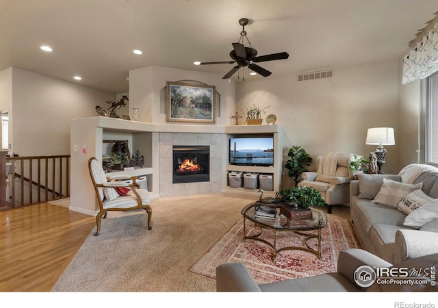 6836 Spanish Bay Dr, Windsor, CO 80550 - living area featuring a ceiling fan, visible vents, a tiled fireplace, wood finished floors, and recessed lighting