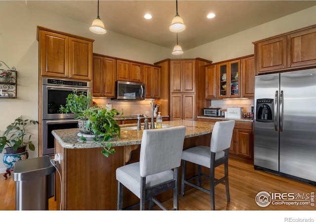 6836 Spanish Bay Dr, Windsor, CO 80550 - kitchen featuring brown cabinets, appliances with stainless steel finishes, and decorative backsplash