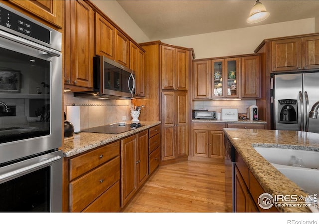 6836 Spanish Bay Dr, Windsor, CO 80550 - kitchen with brown cabinets, stainless steel appliances, and decorative backsplash