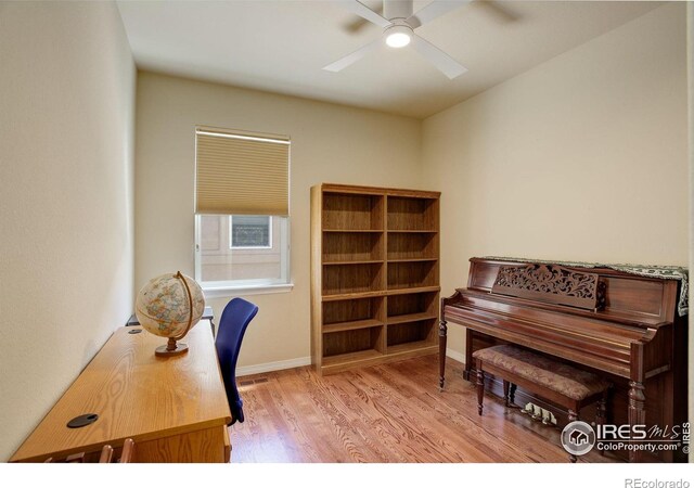 office area with baseboards, ceiling fan, and wood finished floors