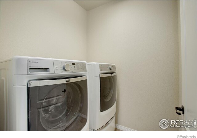 laundry area featuring laundry area, baseboards, and washing machine and clothes dryer