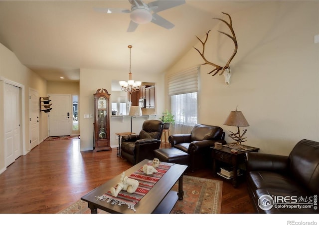 living room with ceiling fan with notable chandelier, wood finished floors, and vaulted ceiling