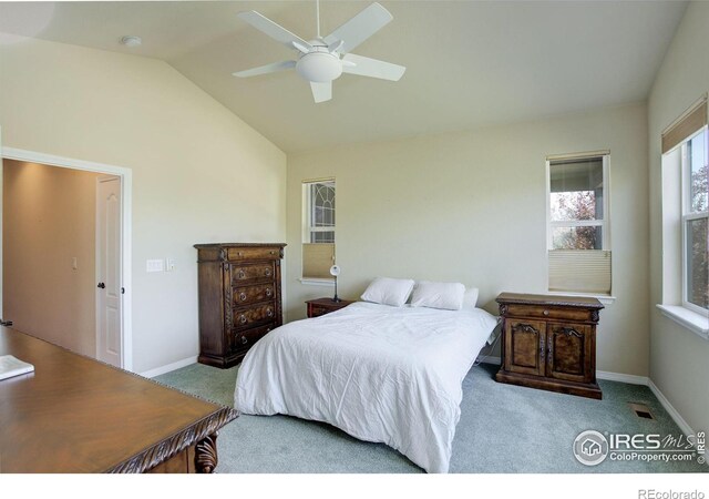 carpeted bedroom with visible vents, baseboards, ceiling fan, and vaulted ceiling