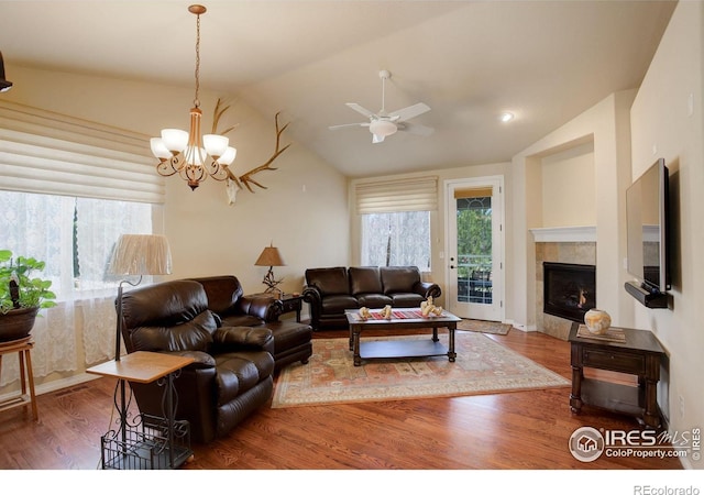 living room featuring wood finished floors, ceiling fan with notable chandelier, lofted ceiling, and a wealth of natural light
