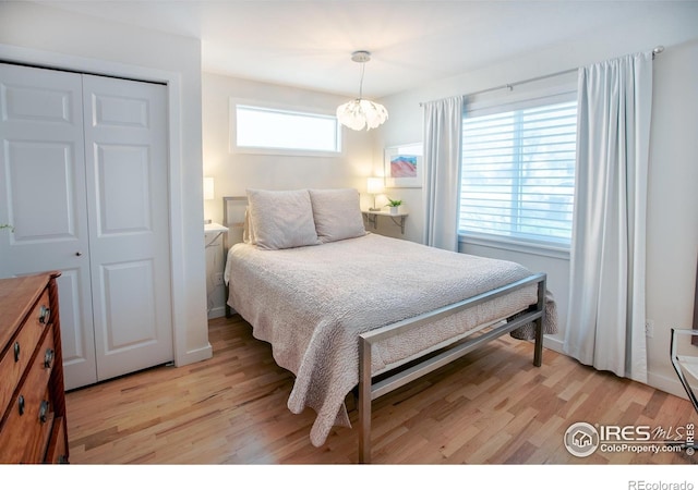 560 Iris Ave, Boulder, CO 80304 - bedroom with light wood-style floors, a closet, and a chandelier