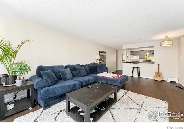 living area with baseboards and wood finished floors