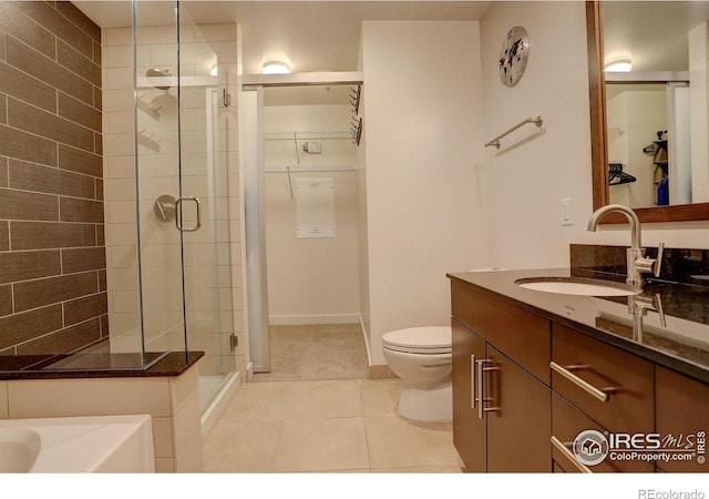 bathroom featuring tile patterned flooring, a stall shower, toilet, and vanity