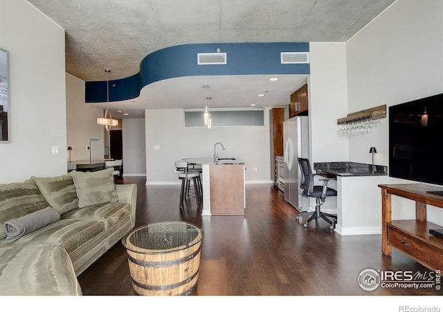 living room featuring dark wood-style flooring, baseboards, and visible vents