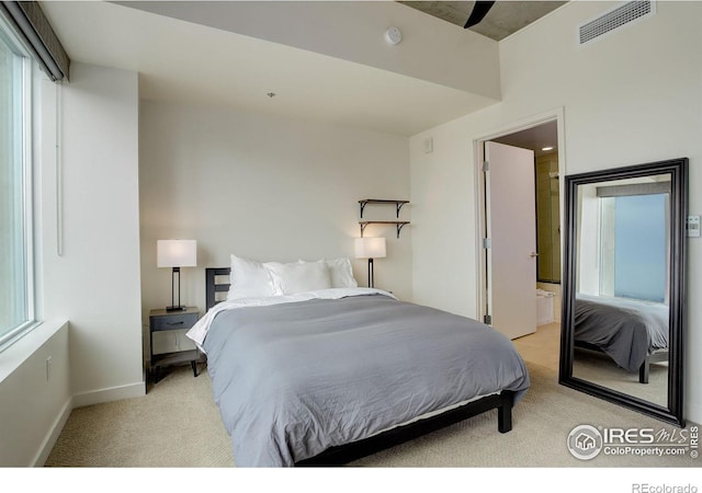 bedroom featuring visible vents, baseboards, and light carpet